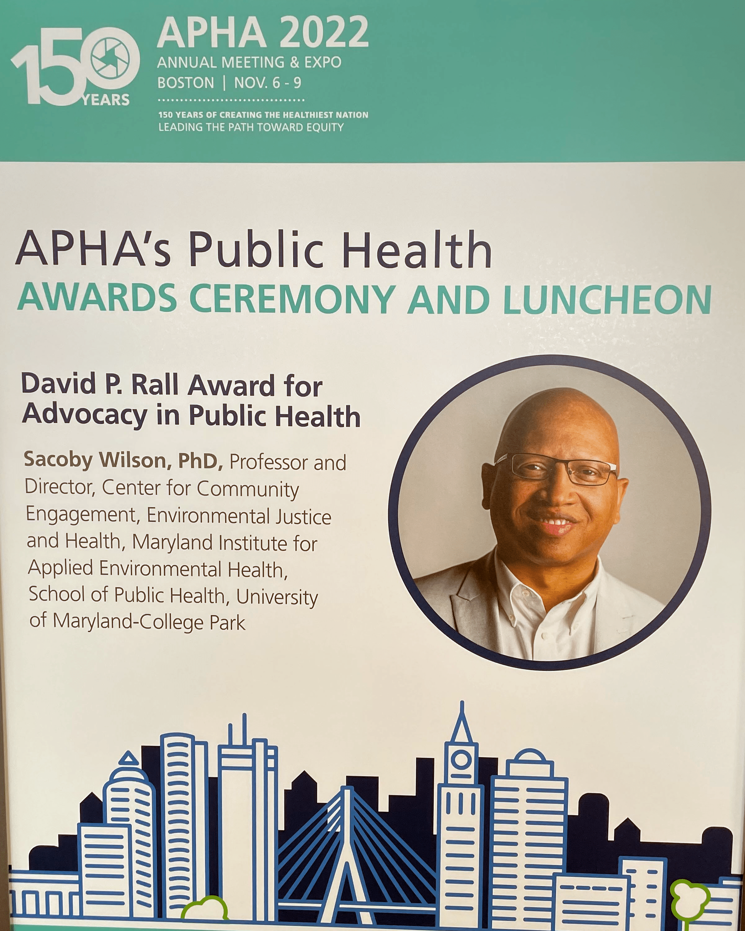 Blue and white sign detailing APHA award for Sacoby Wilson.