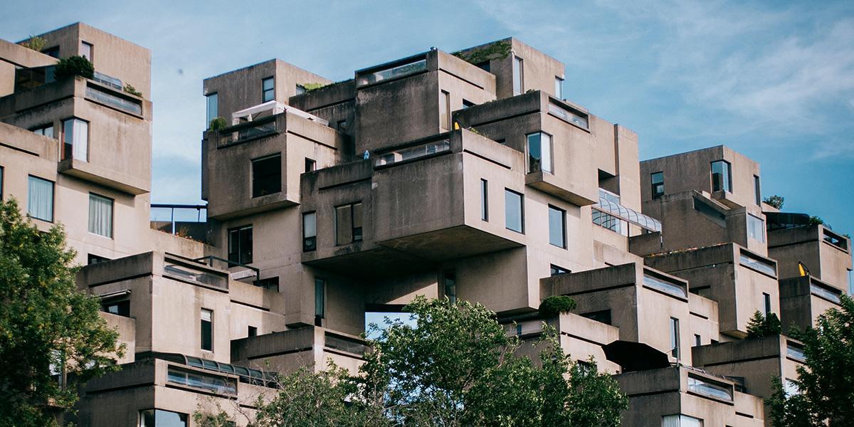 Maze-like exterior of a tan building with a blue sky in the background.