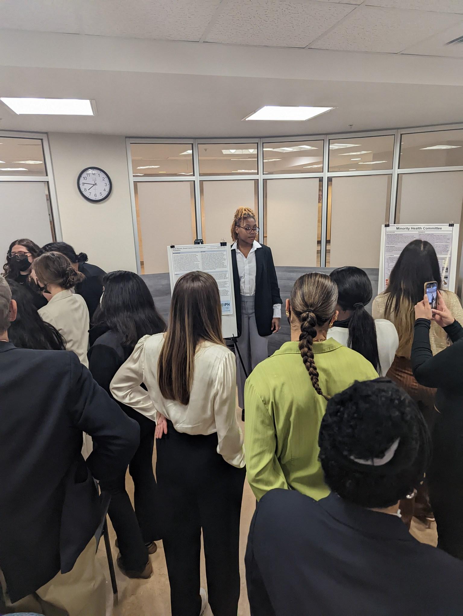 SEIPH member presenting poster to other students.