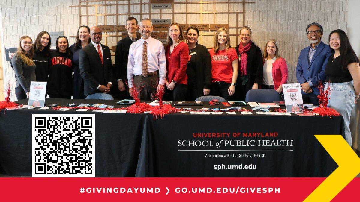 A group of people stand in front of a table bearing the School of Public Health name on it.