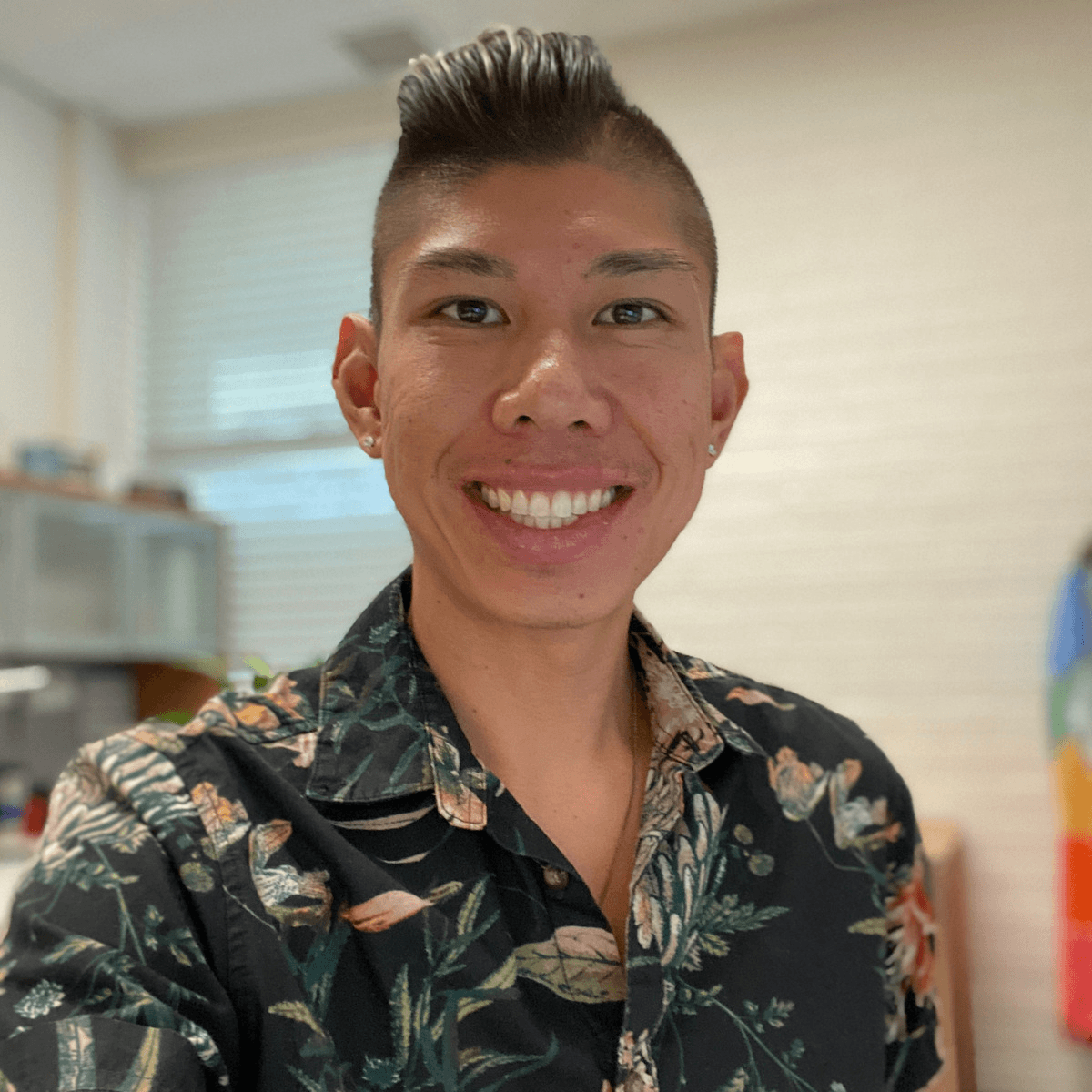 Jordan smiling at camera in a printed shirt.