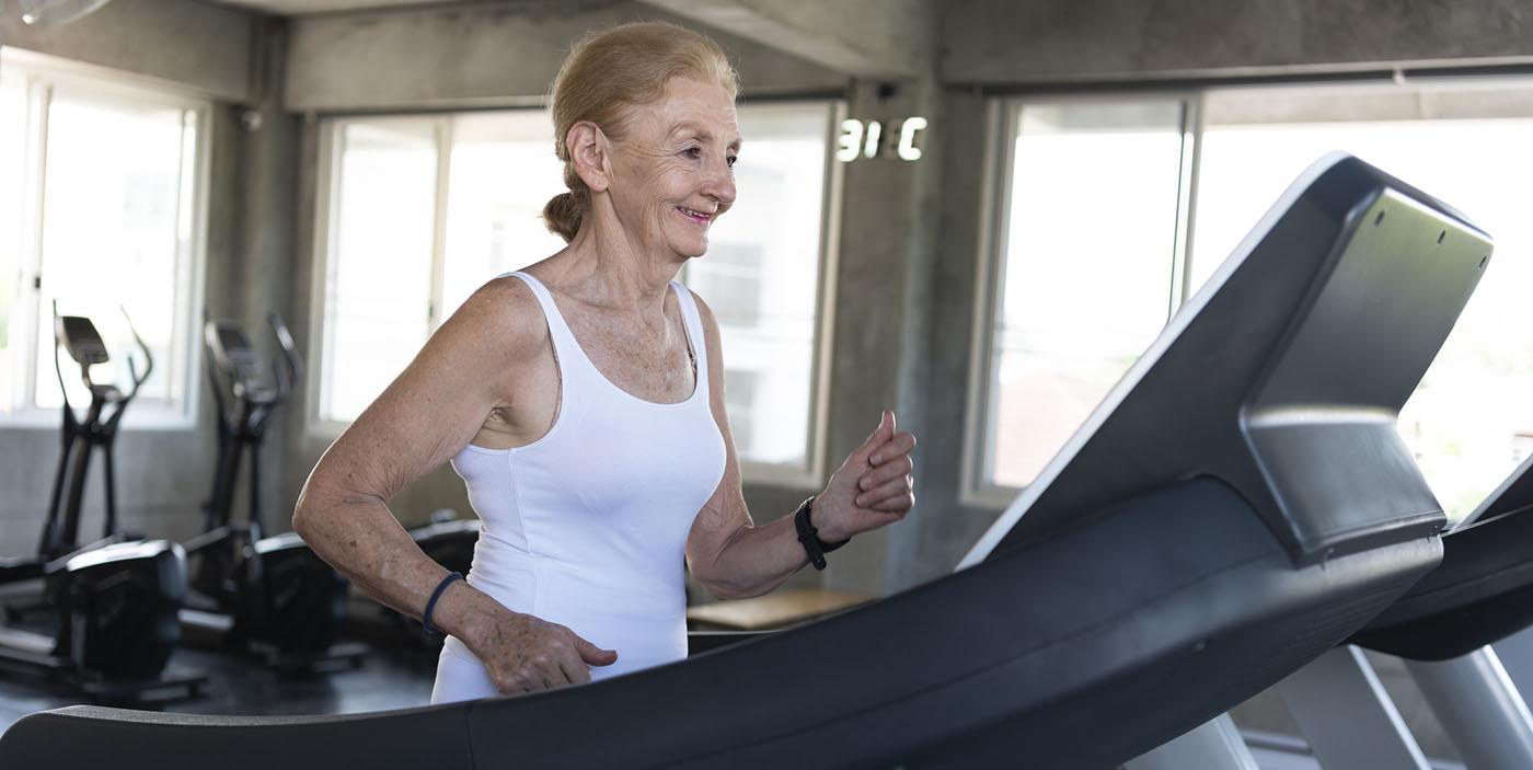 Senior women exercise jogging at gym fitness smiling and happ