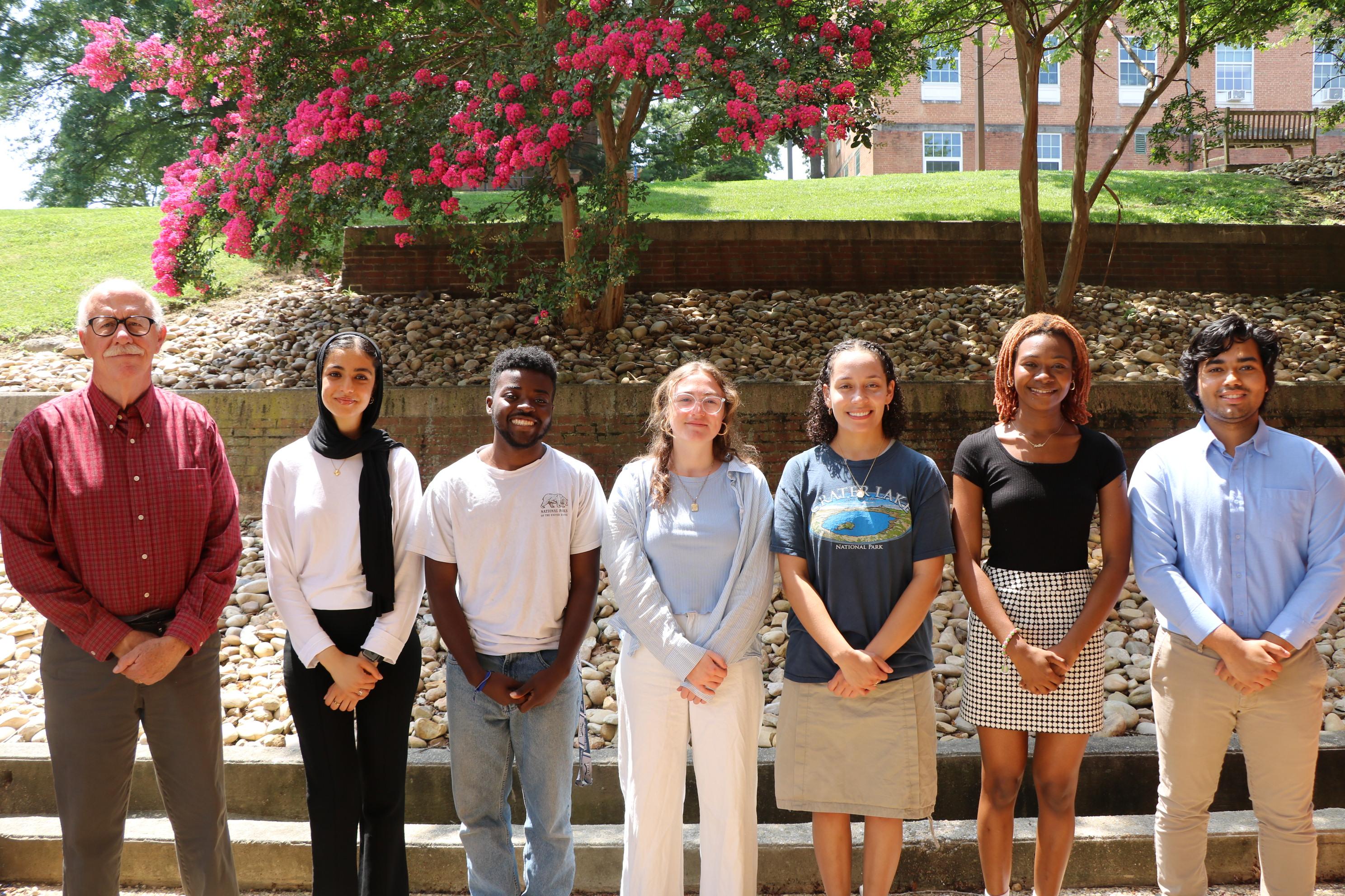 Students and faculty members stand outside of the School of Public Health.