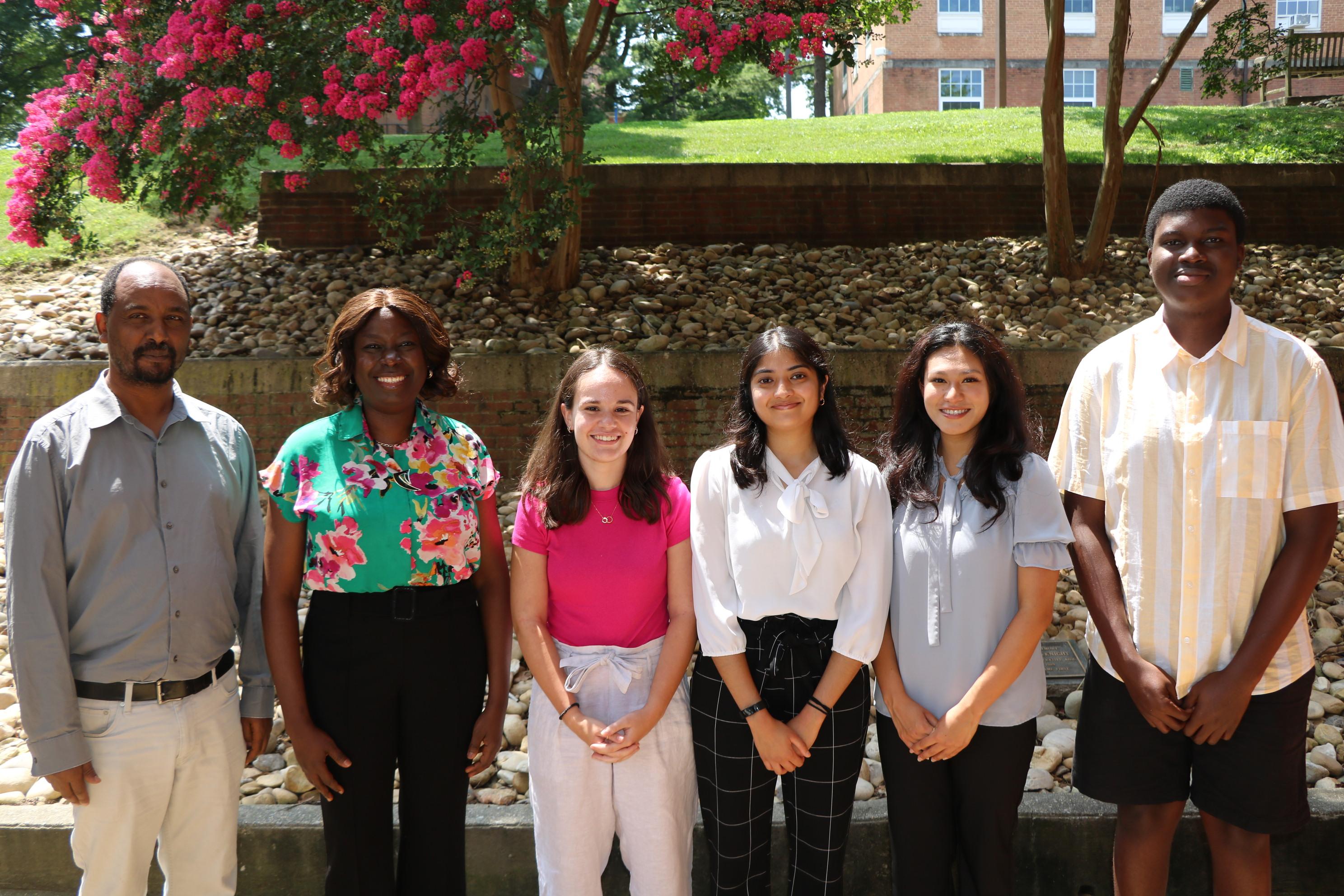 Students and faculty members stand outside of the School of Public Health.