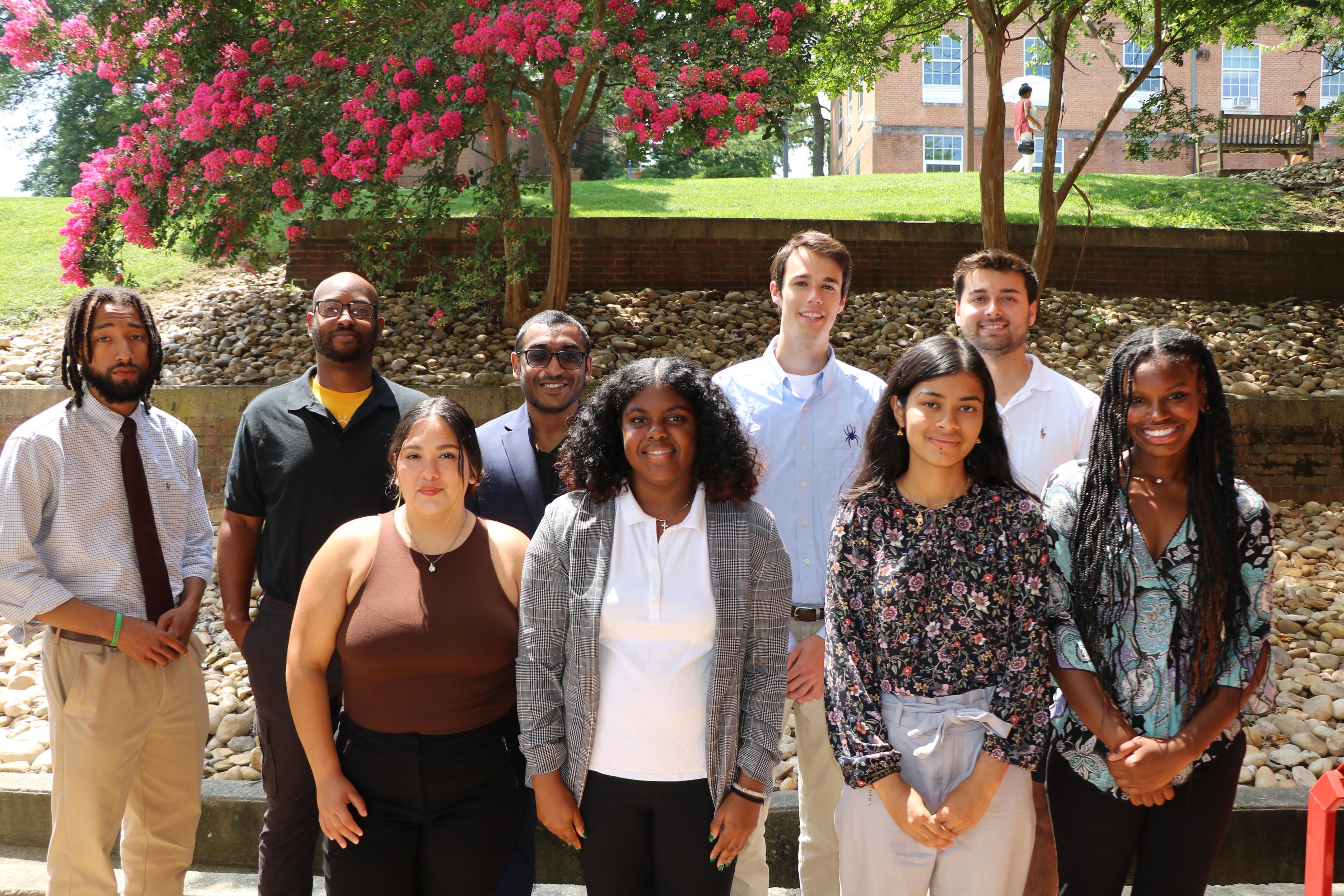 Students and faculty members stand outside of the School of Public Health.