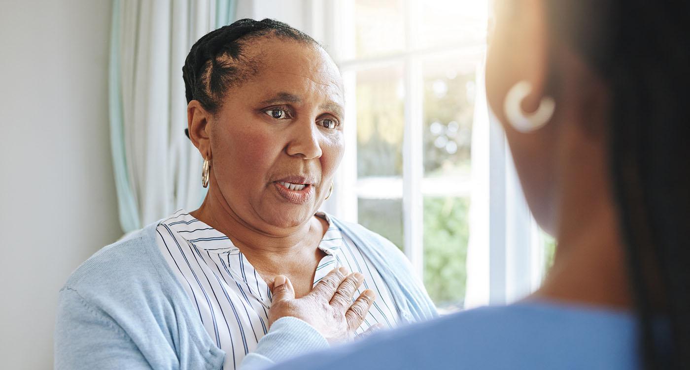 Older women looks distressed as she places her hand over her heart.