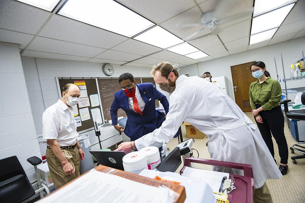 Dr. Pines in a lab setting with three other people. 