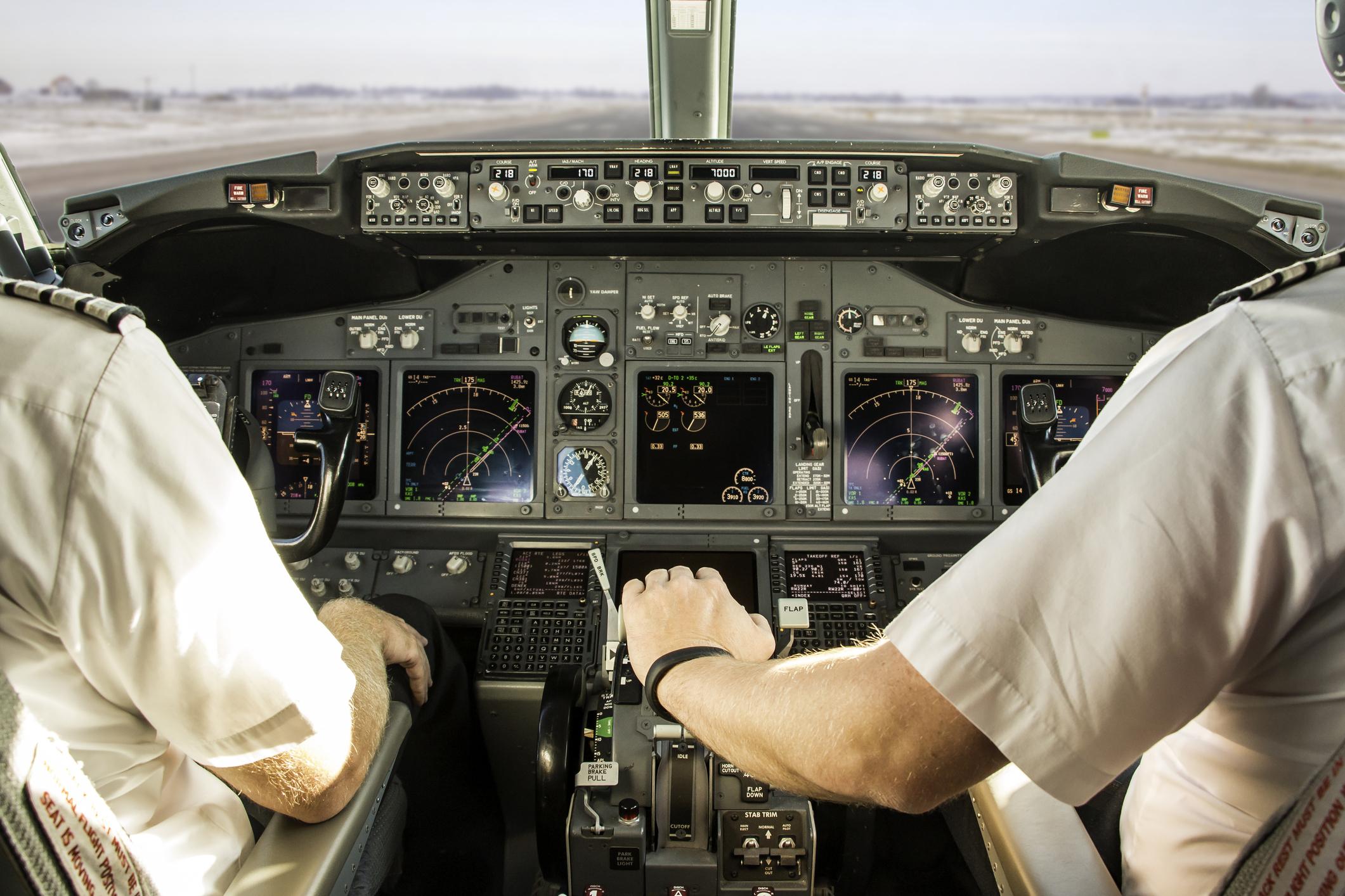 First officer is pushing on thrust levers to speed up aircraft and takeoff.