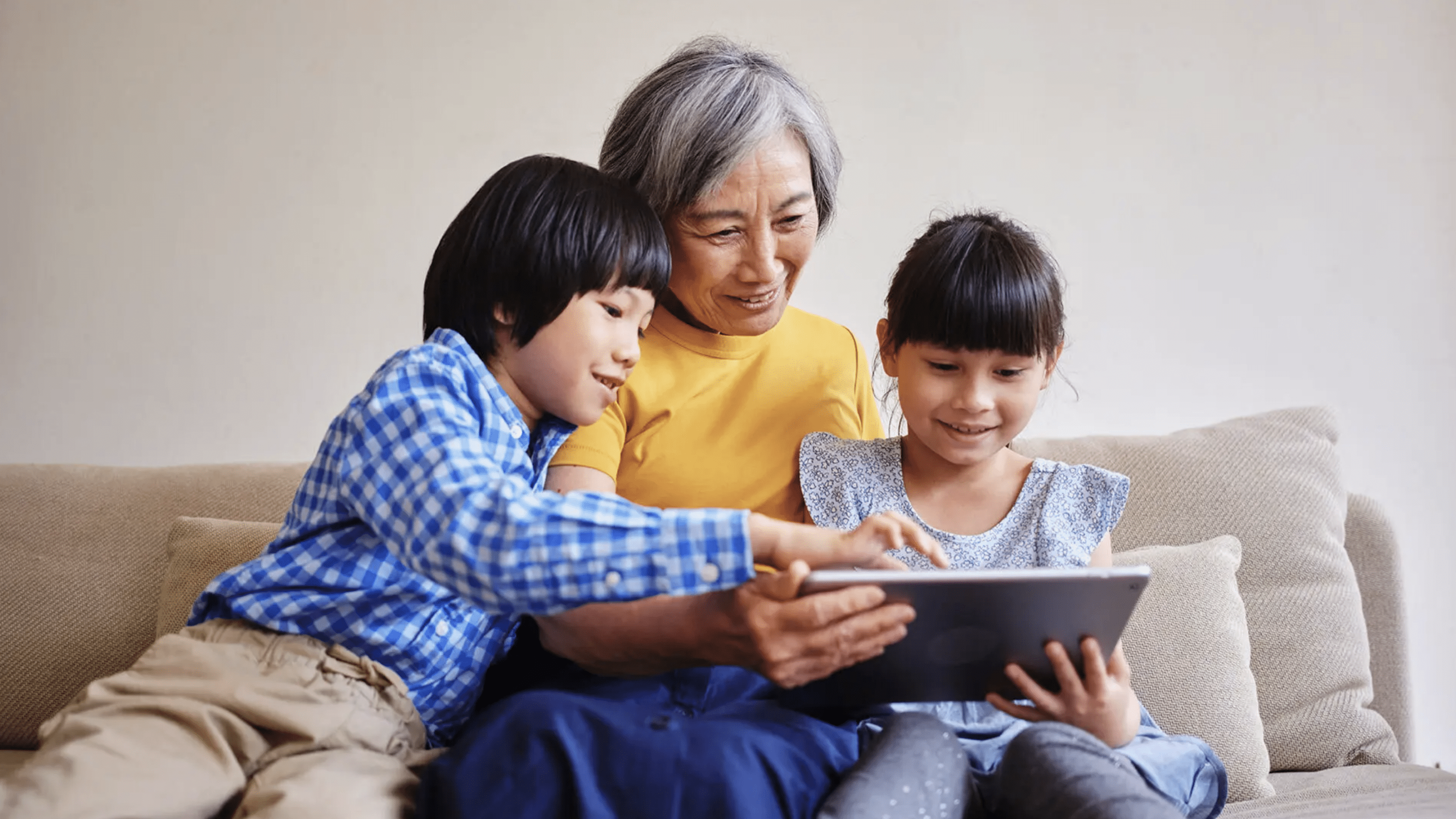 Asian American woman reads books with young children.