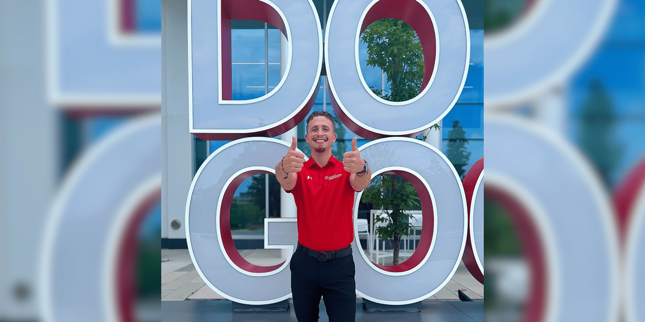 Student in a red polo holding up two thumbs