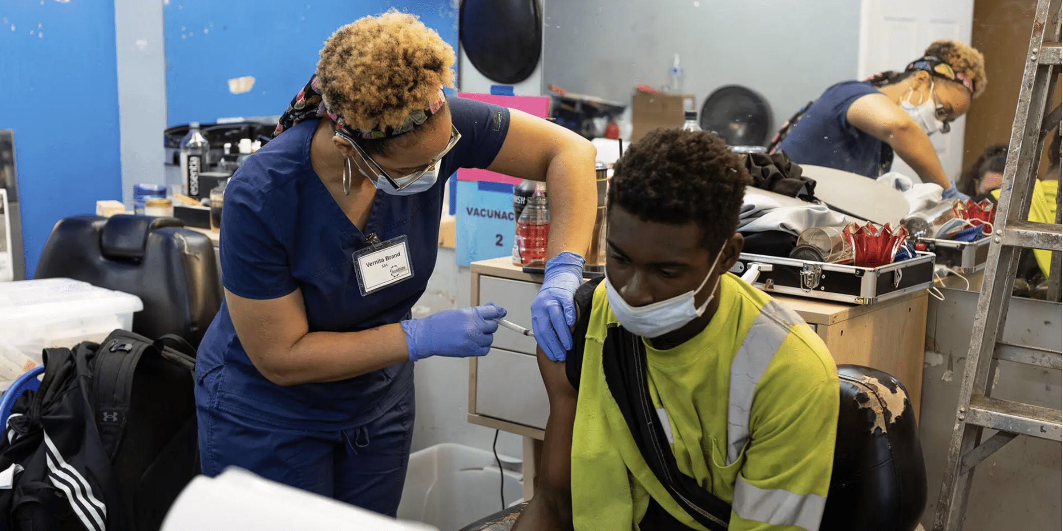 Medical Assistant Vernita Brand gives a COVID-19 vaccine shot to a patron at a clinic held in May at the Shop Spa in Hyattsville. It was the first barbershop-based COVID-19 clinic held in Maryland, organized by the HAIR campaign at the UMD School of Public Health.
