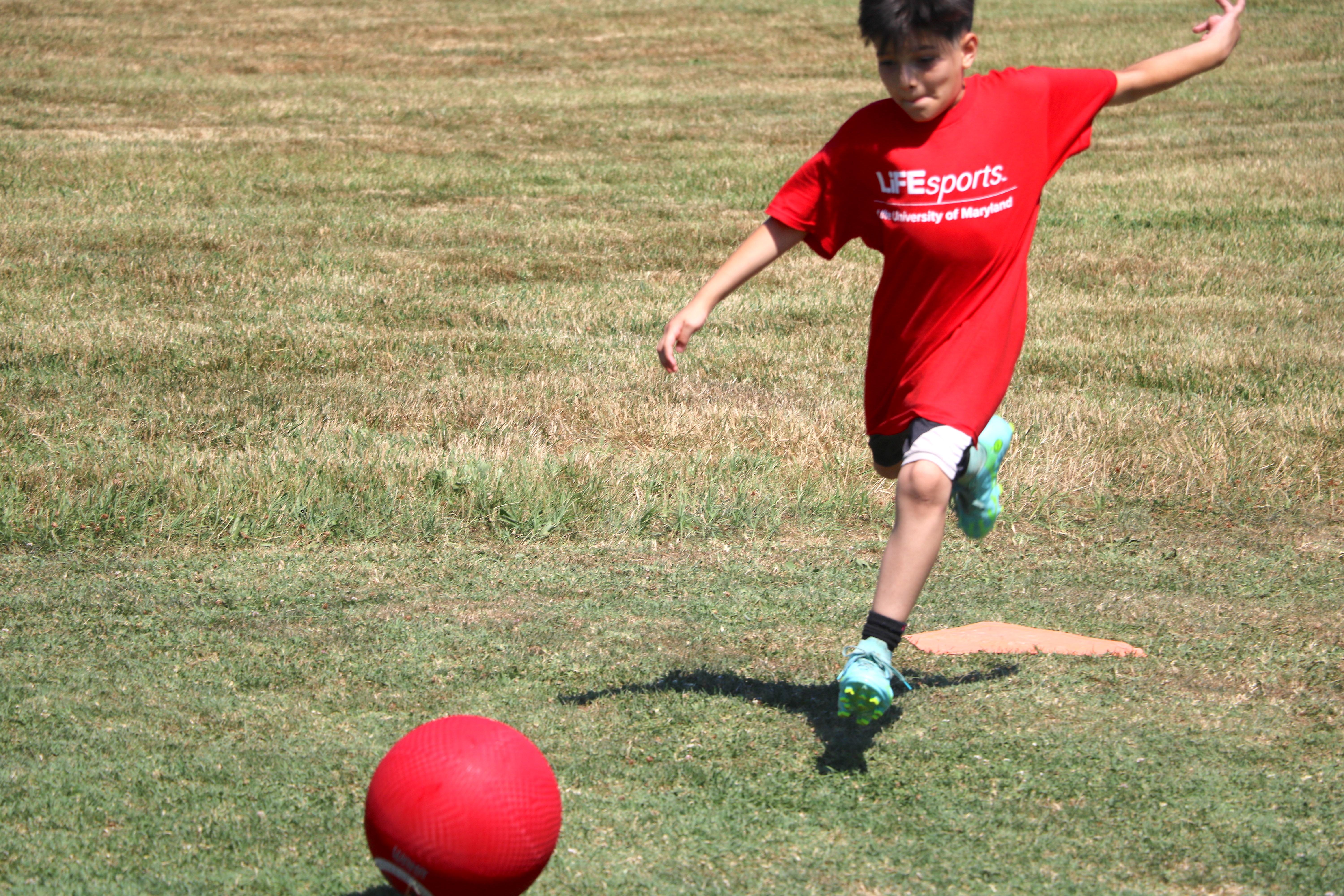 Kid kicking a kickball