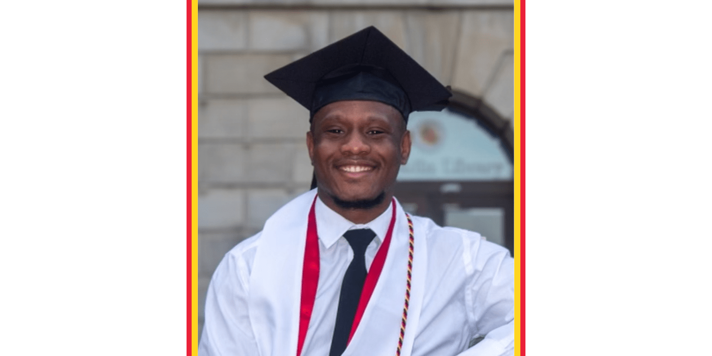 Student in cap and gown smiles at the camera