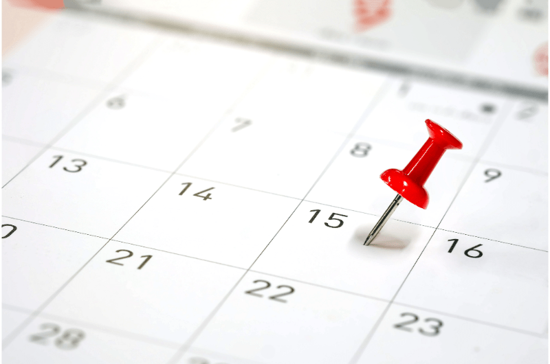 Monthly calendar with a red push pin in one date