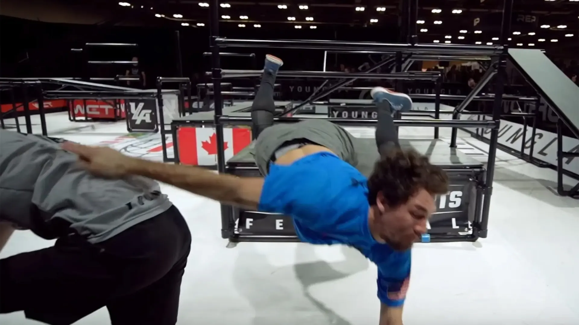 Student in the air touching other student in the back after jumping through an obstacle