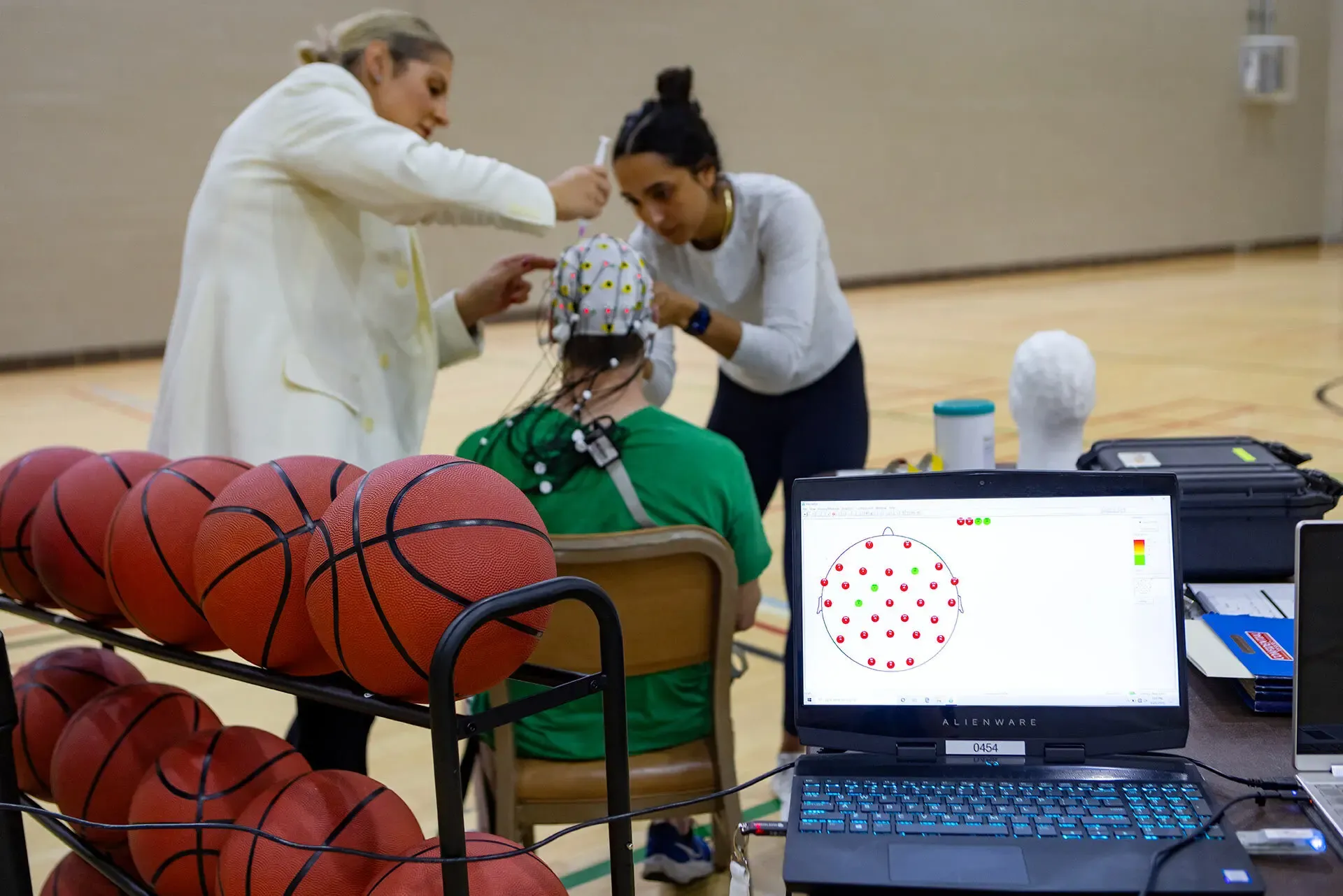 Lab associate putting gel on subjects EEG cap