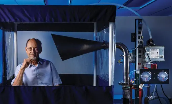 Professor Donald Milton poses with the Gesundheit II machine.