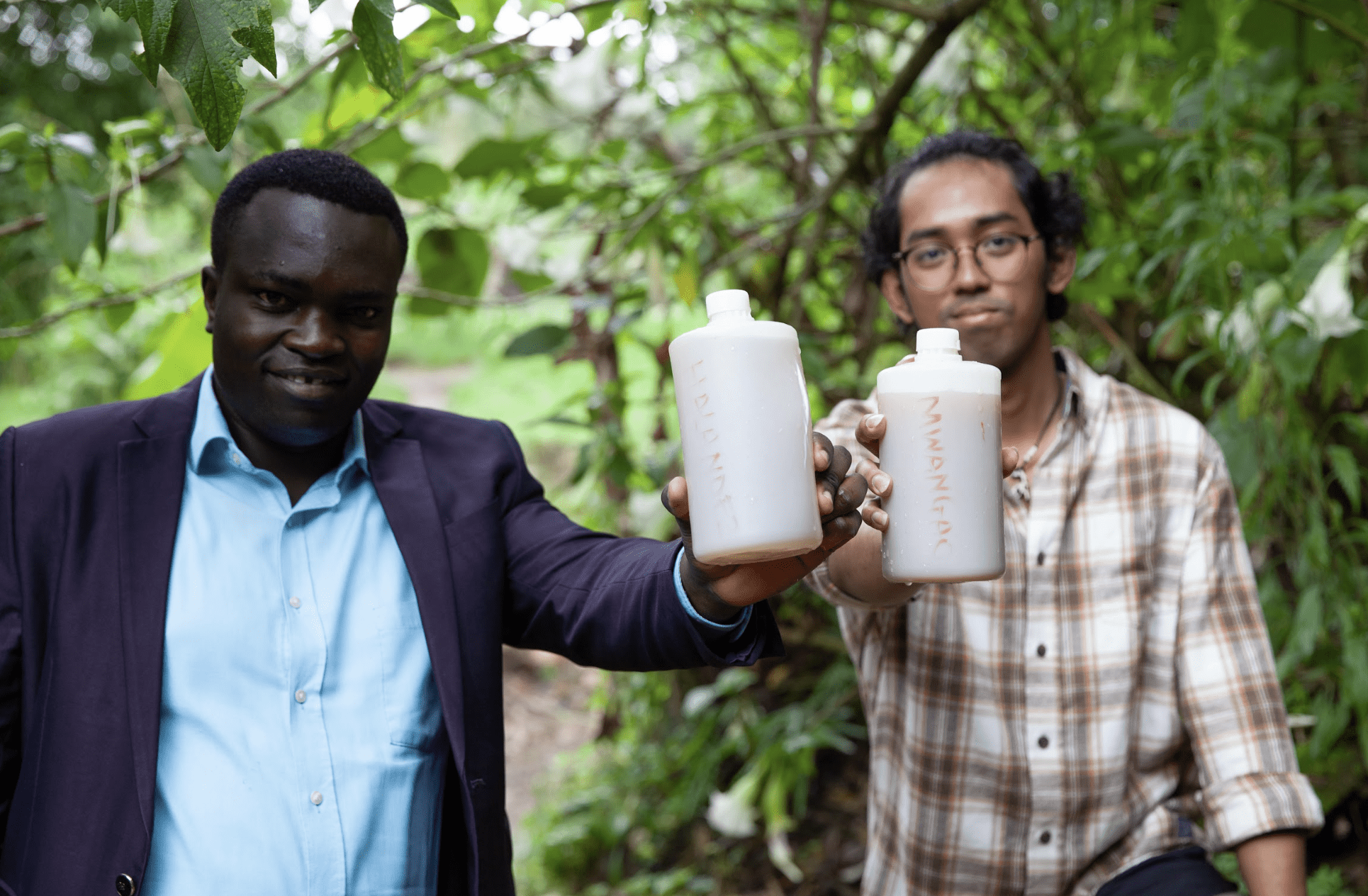 Student hold water samples with Tanzanian professor