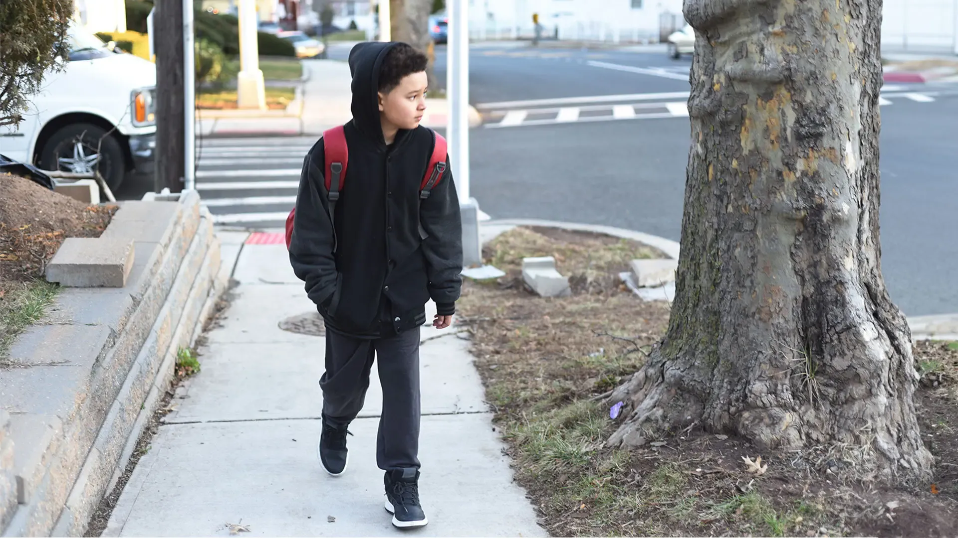 Little boy walking on a sidewalk