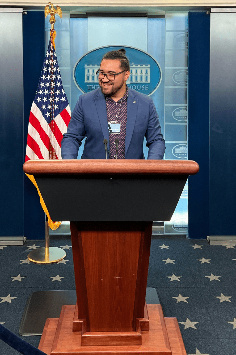 Alum stands at White House podium