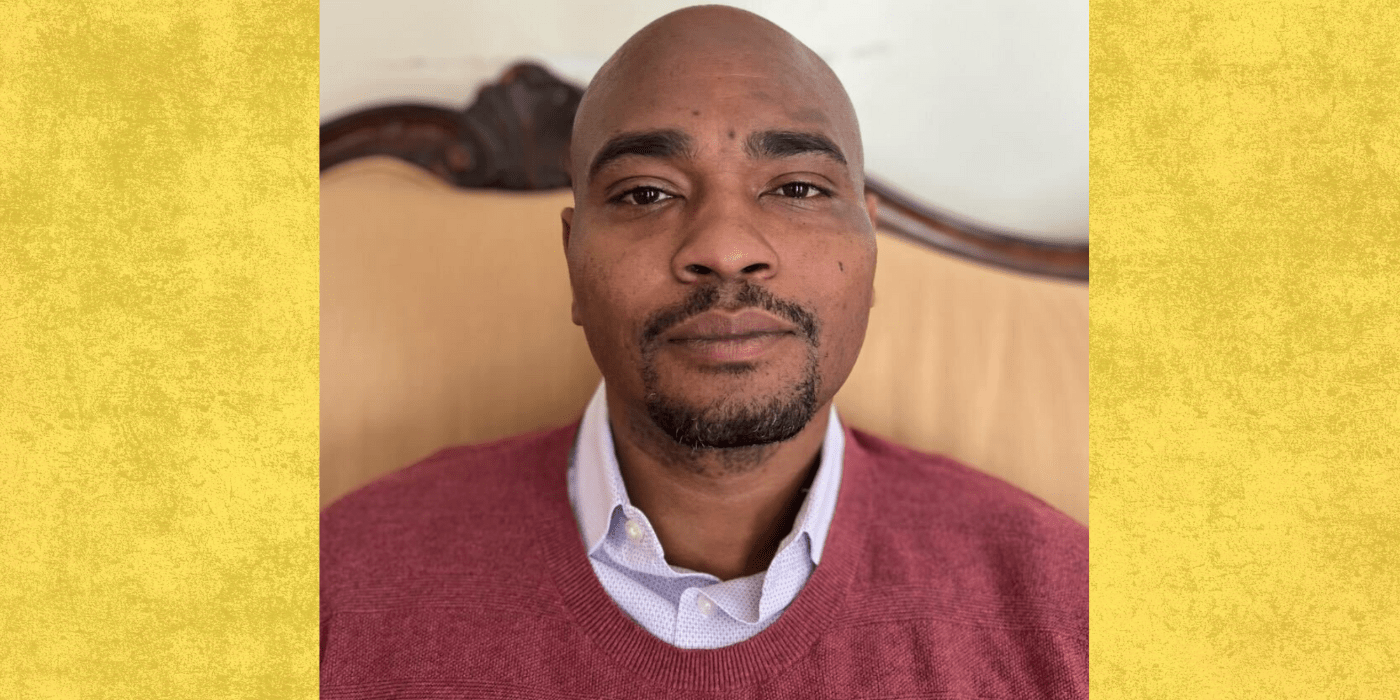 Black doctoral student headshot wearing red sweater