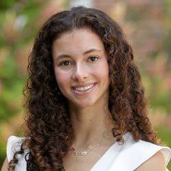 female student headshot with long curly brown hair