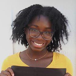 smiling black female student headshot with curly brown hair