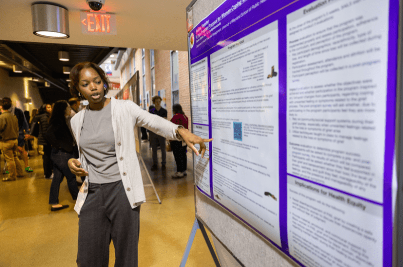 student explaining research poster