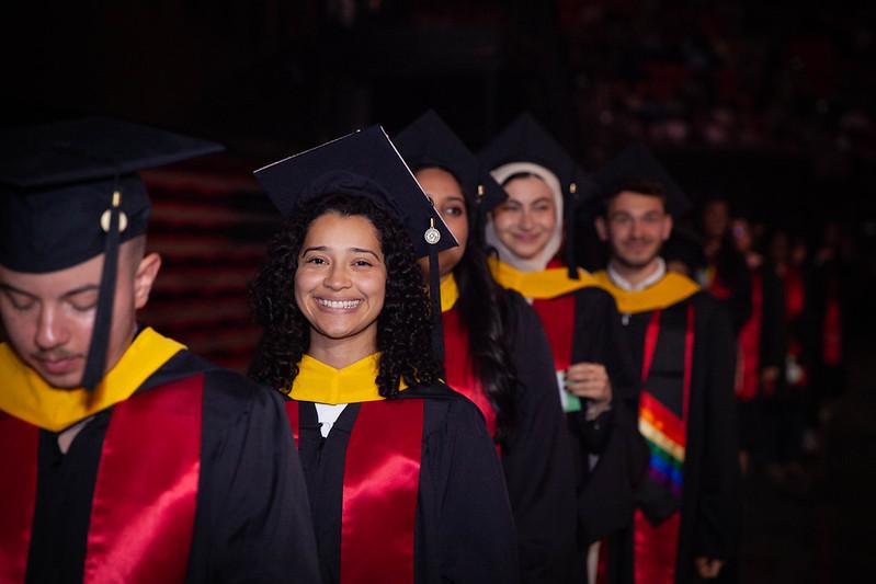 Group of UMD graduates with one smiling at camera