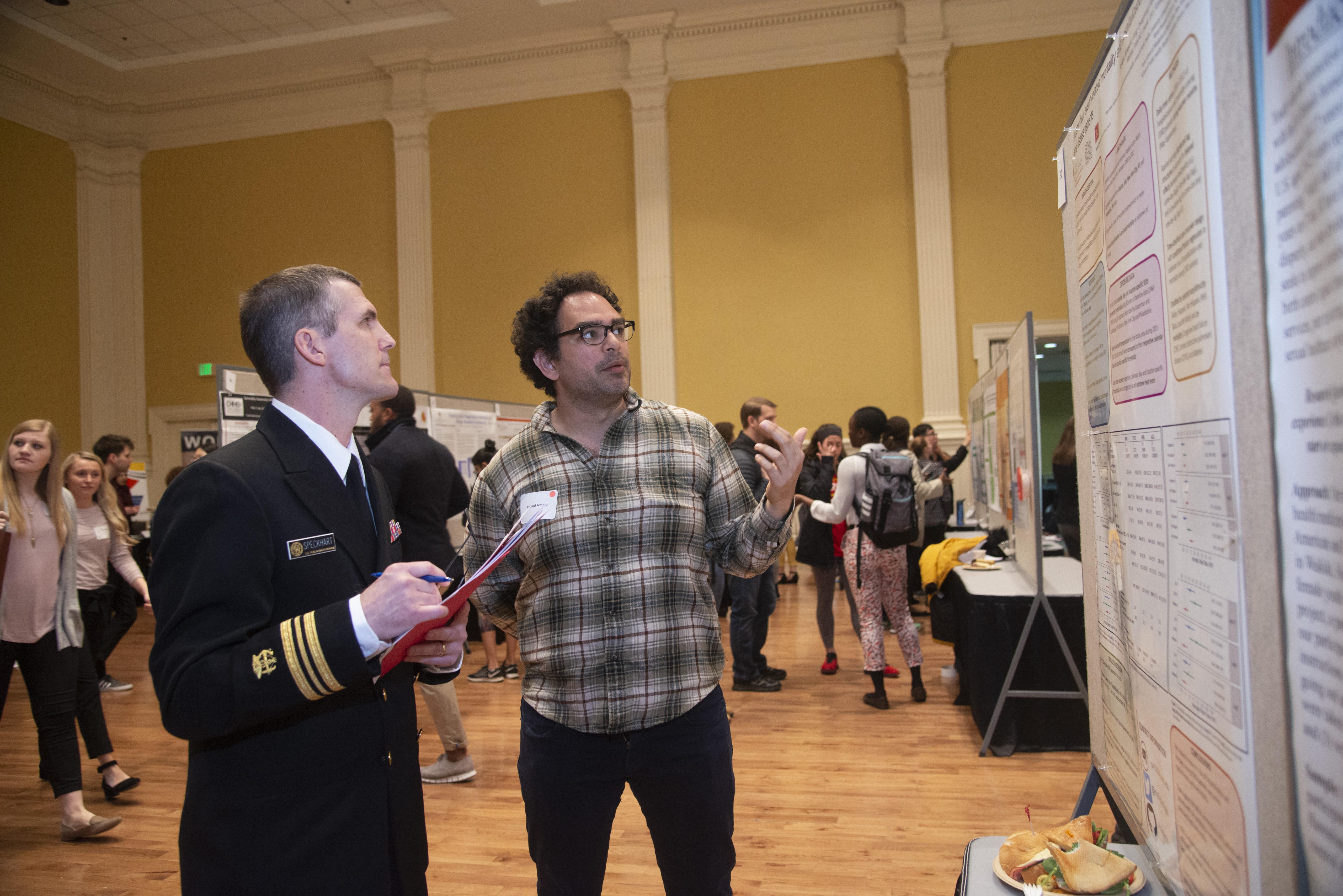 male student explaining his poster presentation
