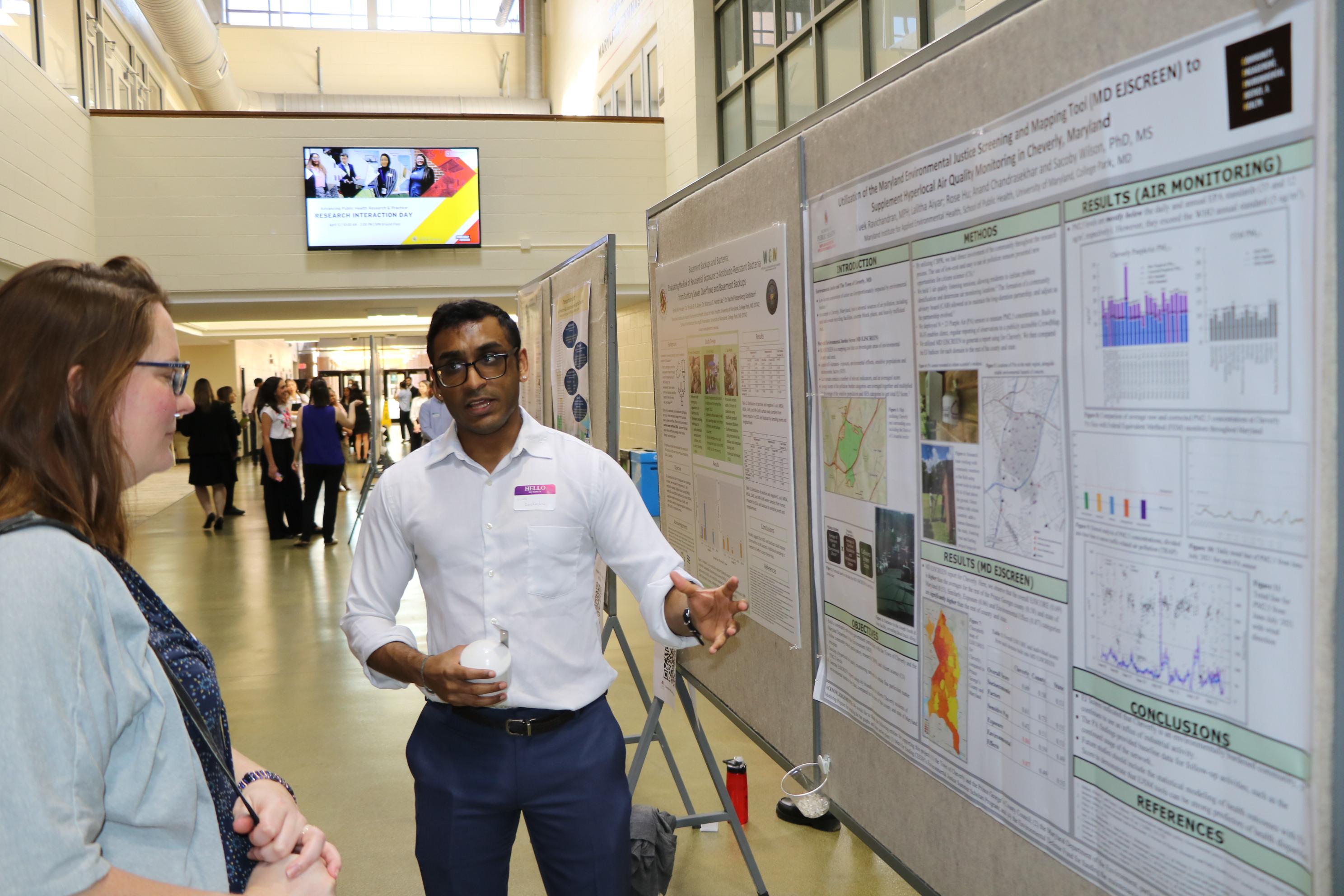 male student explaining his poster presentation