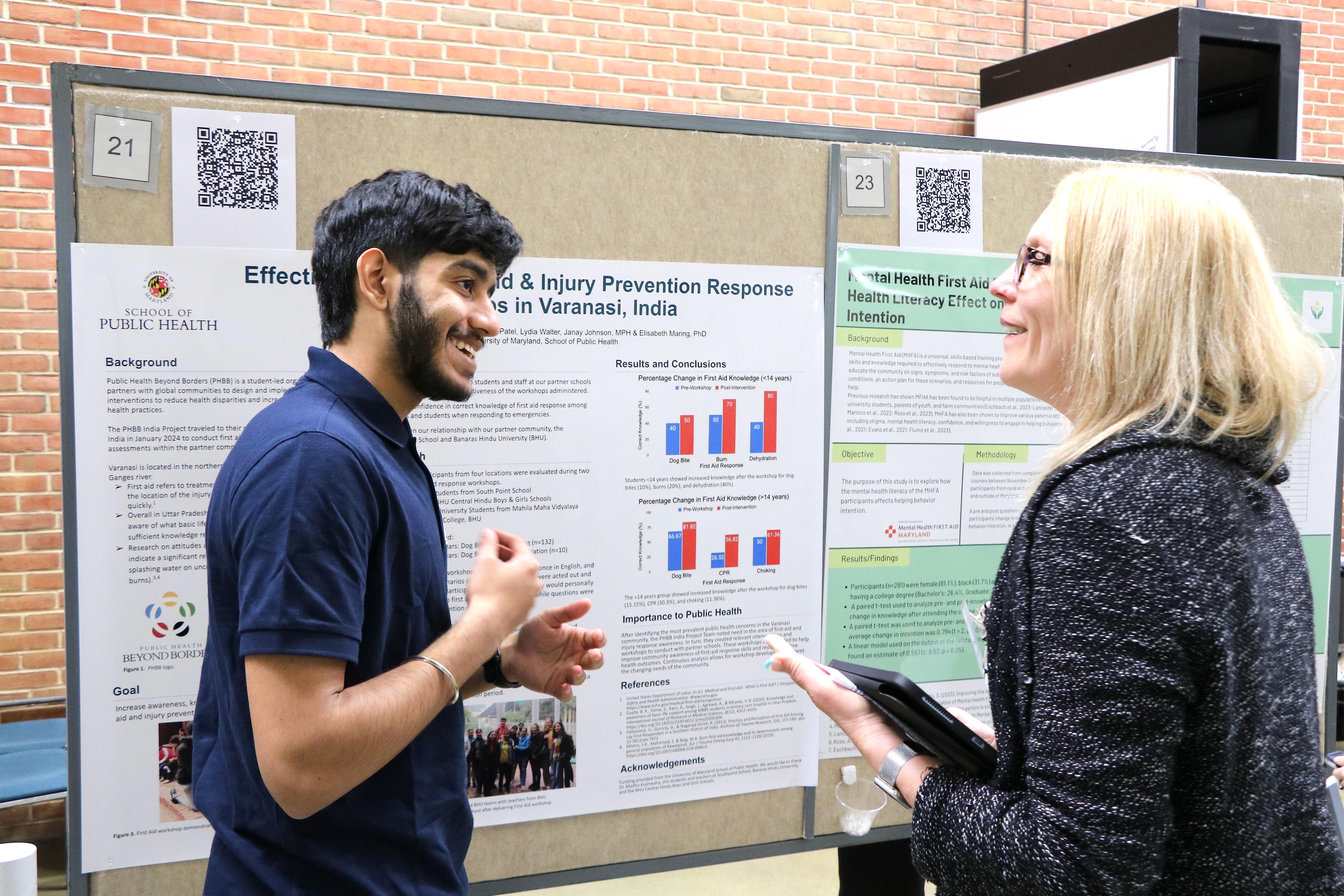 male student speaking to female professor about his poster presentation