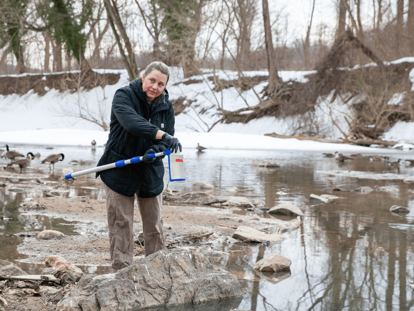 grad student takes a water sample near the Potomac river sewage spill site