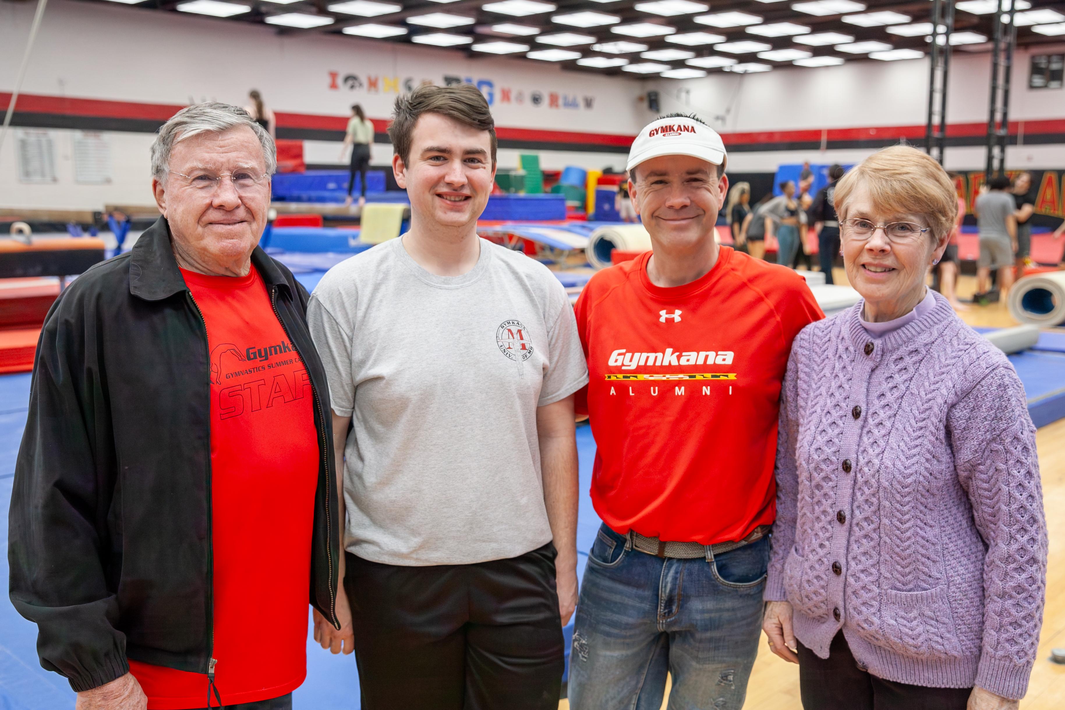 three generations of one family poses for the camera with people in the background of the Gymkana gym