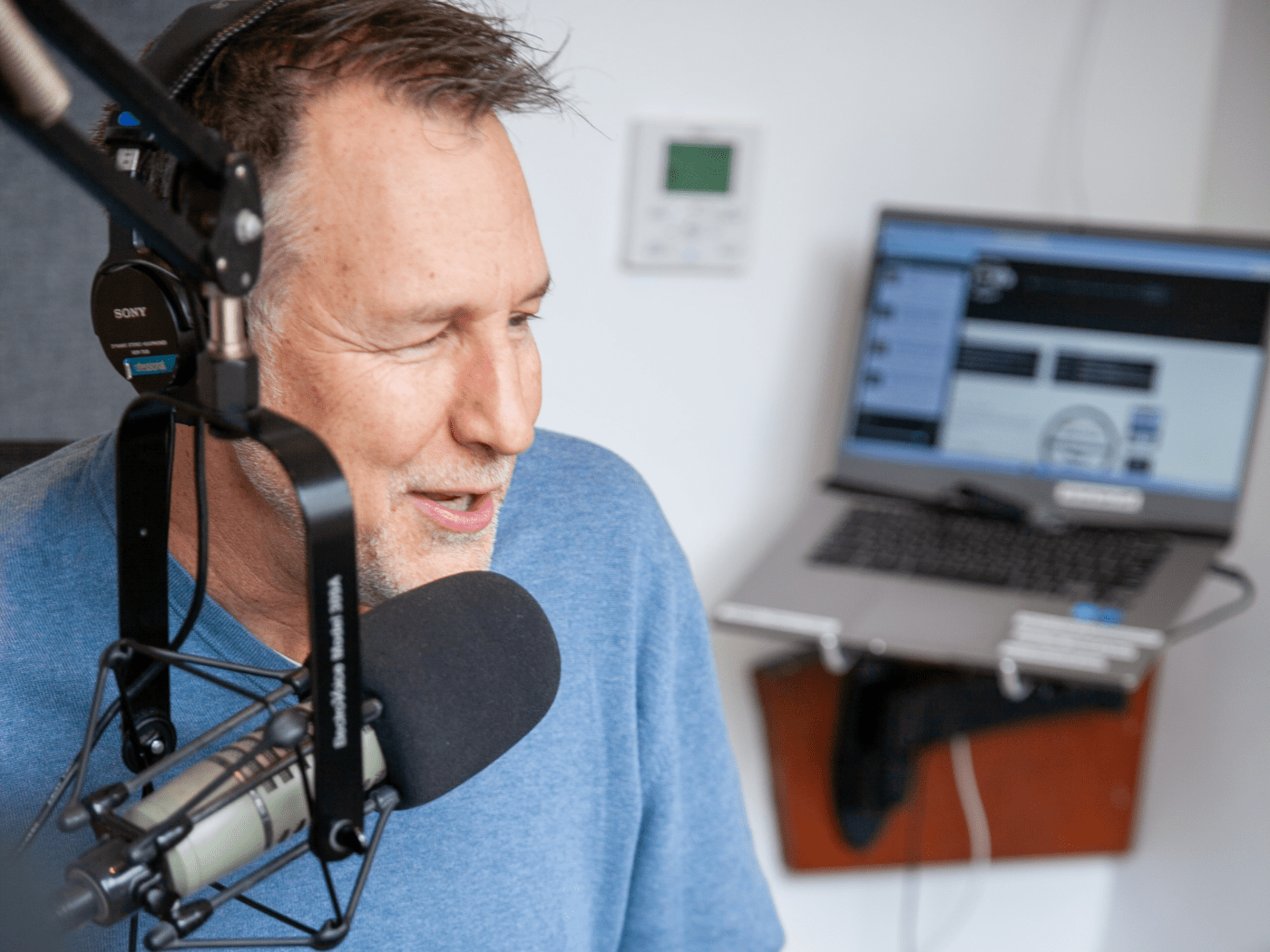 Professor and DJ speaks into the mic at a radio