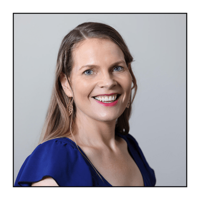 Woman smiling to camera headshot, wearing blue top
