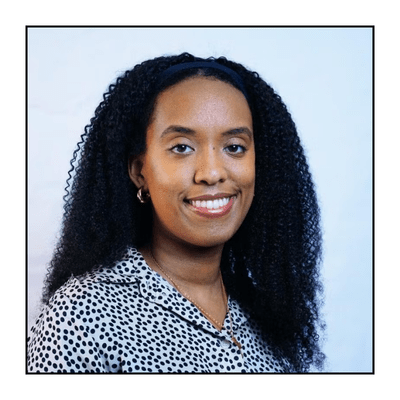 Black woman professor wearing black and white patterned shirt smiles to camera