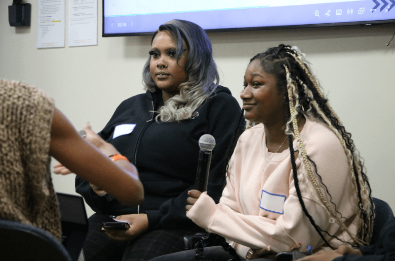 two female youths on a panel discussion