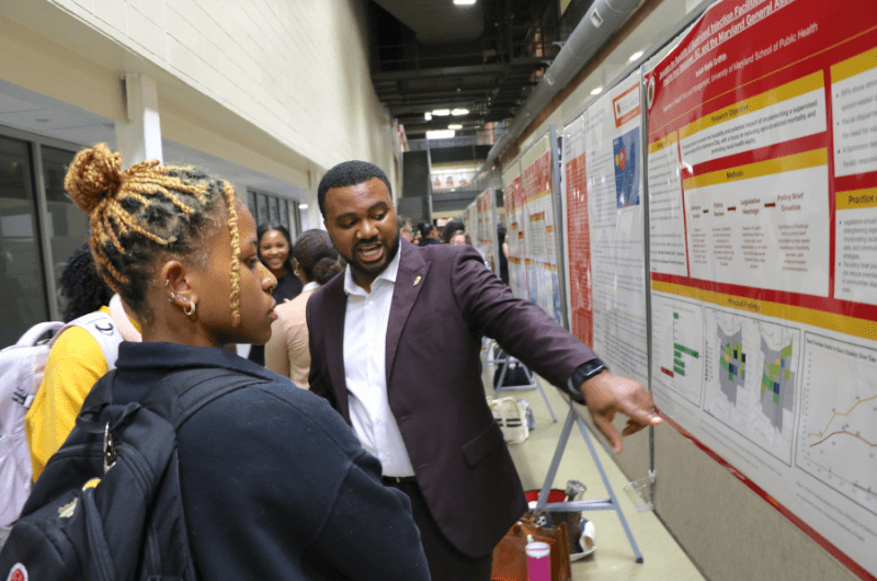 student explaining research poster