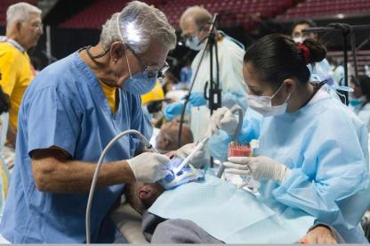Dental professionals provide care to a patient during a dental procedure.