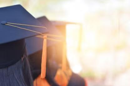 Graduate wearing a cap and gown at a commencement ceremony.